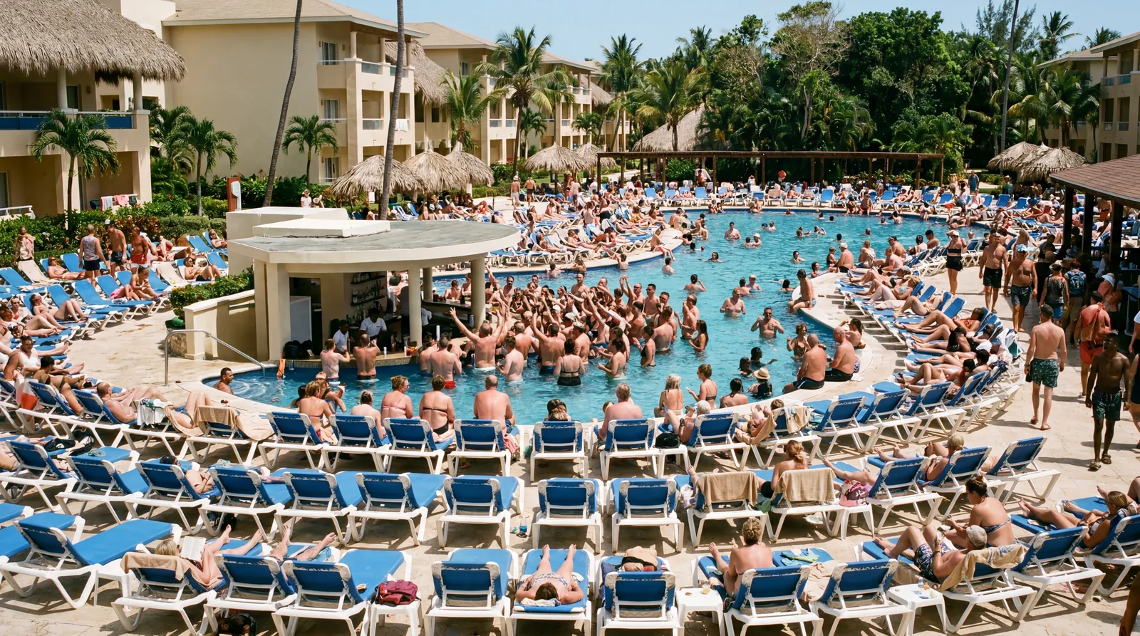 Realistic editorial photo of adults-only Caribbean resort pool with loud bar area, loungers, and evening party lights st