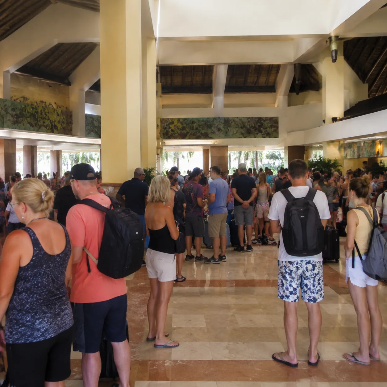 Square documentary travel photo of a large budget all-inclusive hotel tower in Punta Cana, crowded lobby, wristband tour