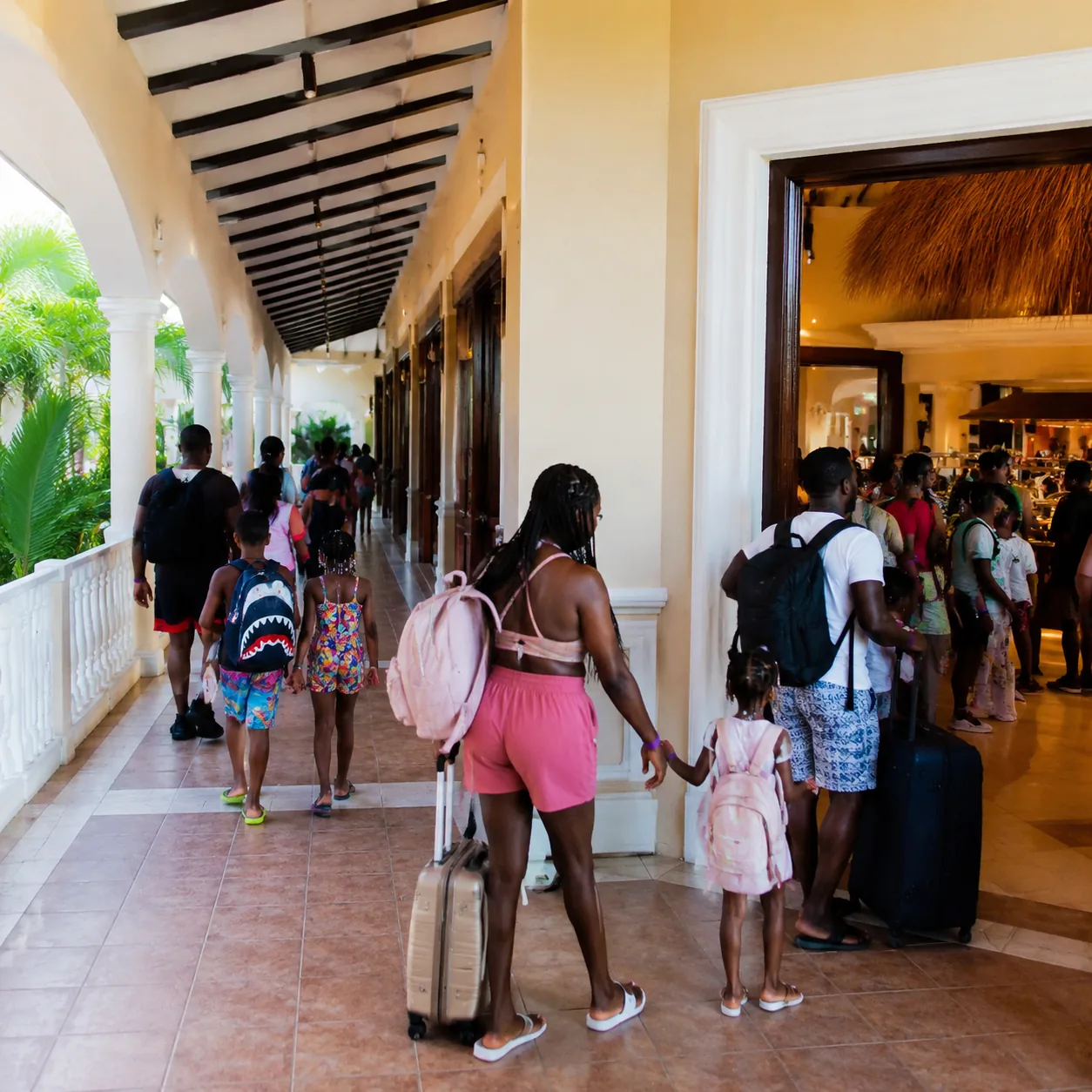 Square editorial travel photo of a massive Jamaica all-inclusive resort complex, long corridors, busy buffet entrance, f
