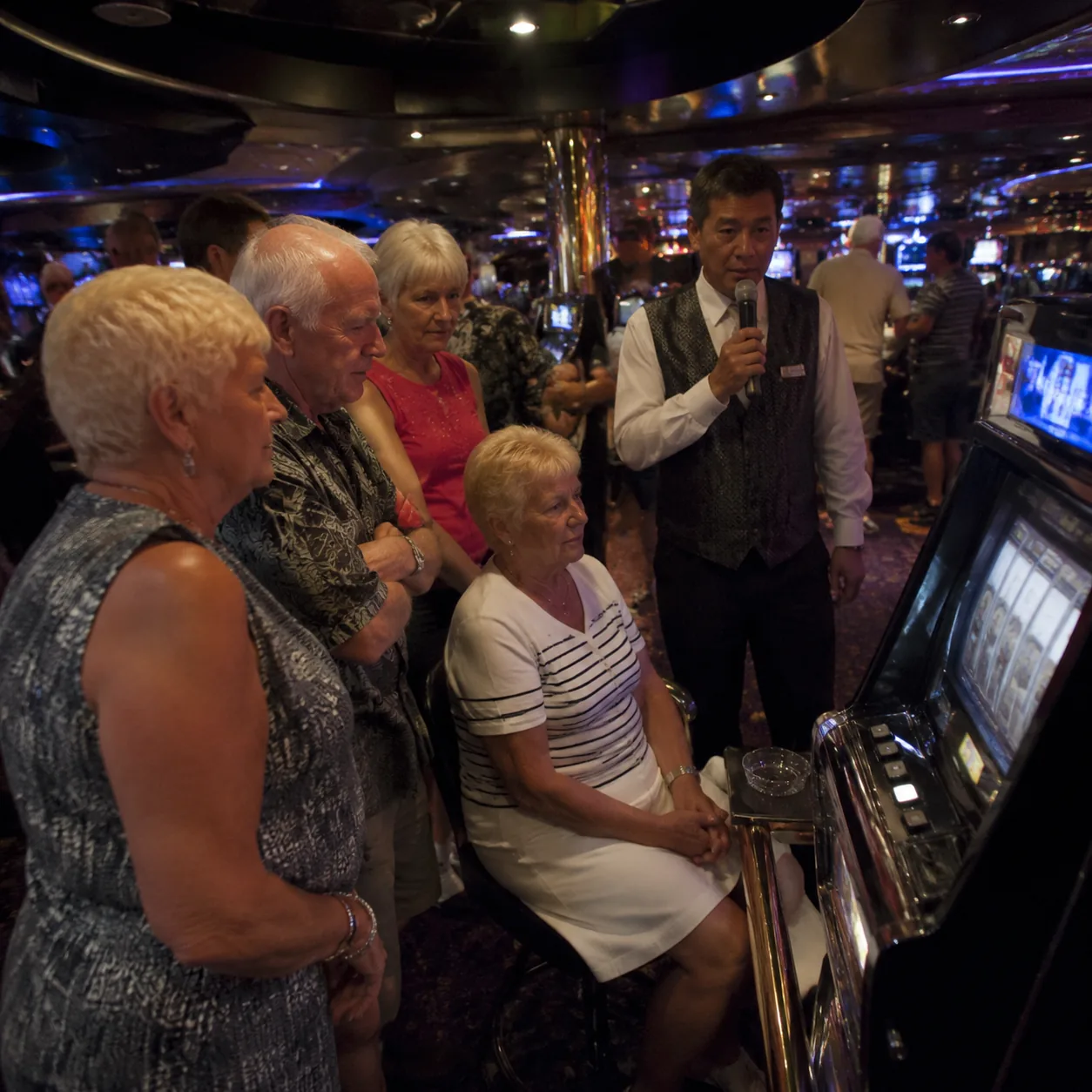 Realistic editorial photo of a quiet cruise ship casino with slot machines, players cards, and dim colorful lighting, no