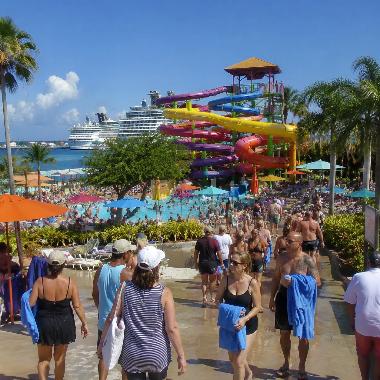 Downtown Nassau resort waterpark near cruise port, colorful slides, crowded pool deck, cruise passengers walking with to