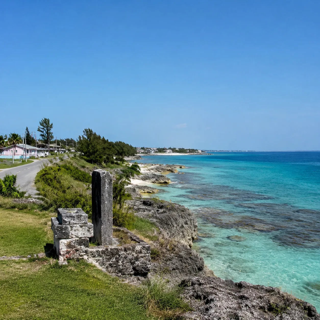 San Salvador Bahamas quiet beach with reef water, small settlement road, historic marker area, wide empty sky