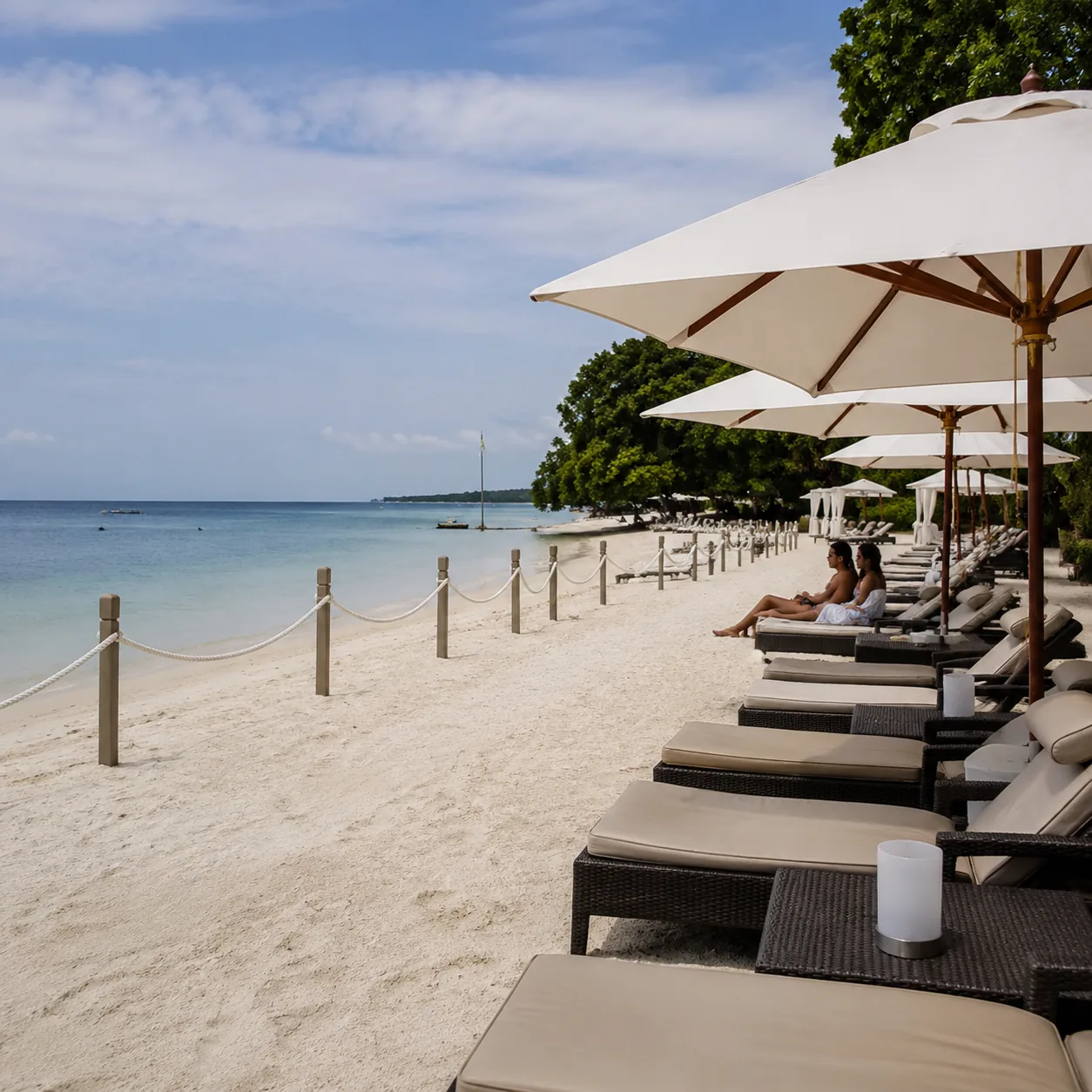 Square editorial travel photo of an adults-only Negril beach resort with pretty sand but sterile resort seating, quiet c
