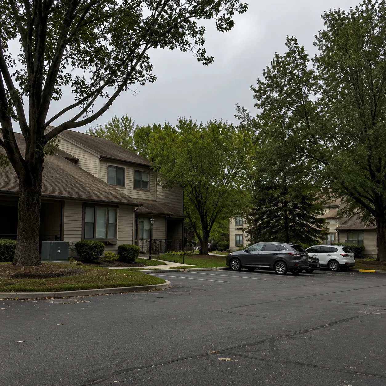 Realistic editorial photo of a Monroe Township New Jersey retirement condo community with older buildings, mature trees,