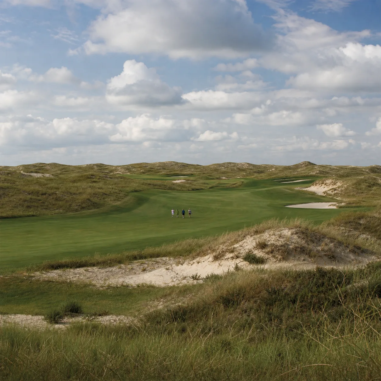 Realistic editorial photo of a remote Nebraska Sandhills golf course with huge rolling dunes, native grasses, wide fairw