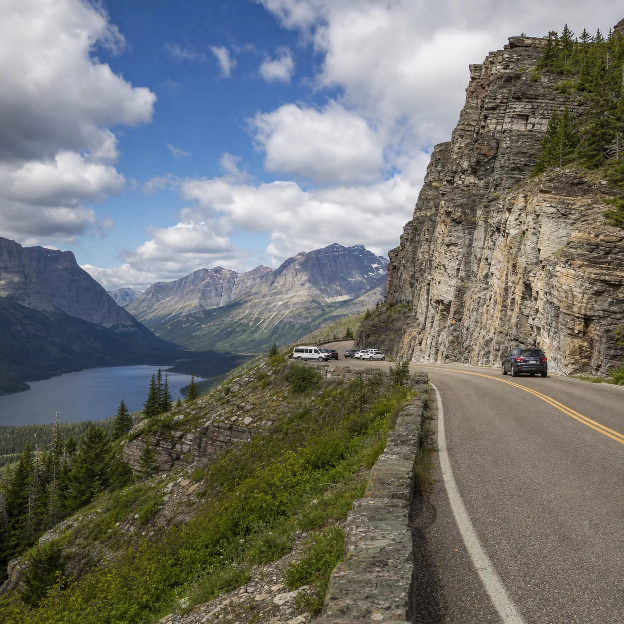 Realistic editorial photo of Going-to-the-Sun Road in Glacier National Park with a mountain wall, lake in the distance,