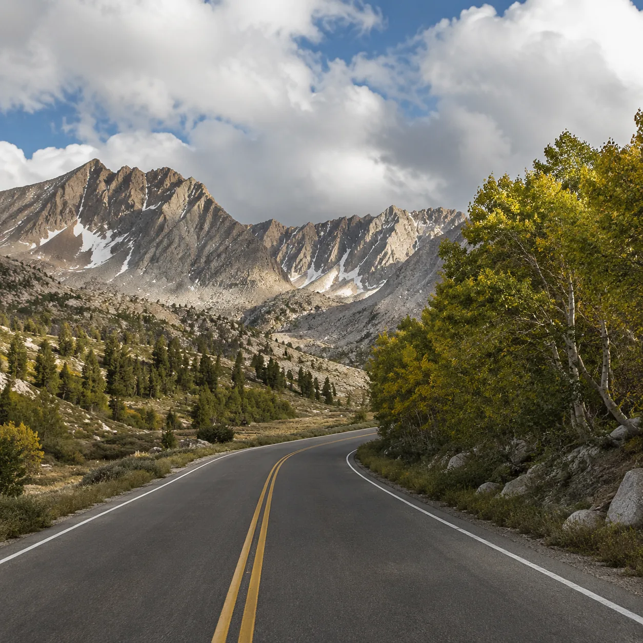 Realistic editorial photo of alpine road through Lamoille Canyon in the Ruby Mountains Nevada, warm natural travel light
