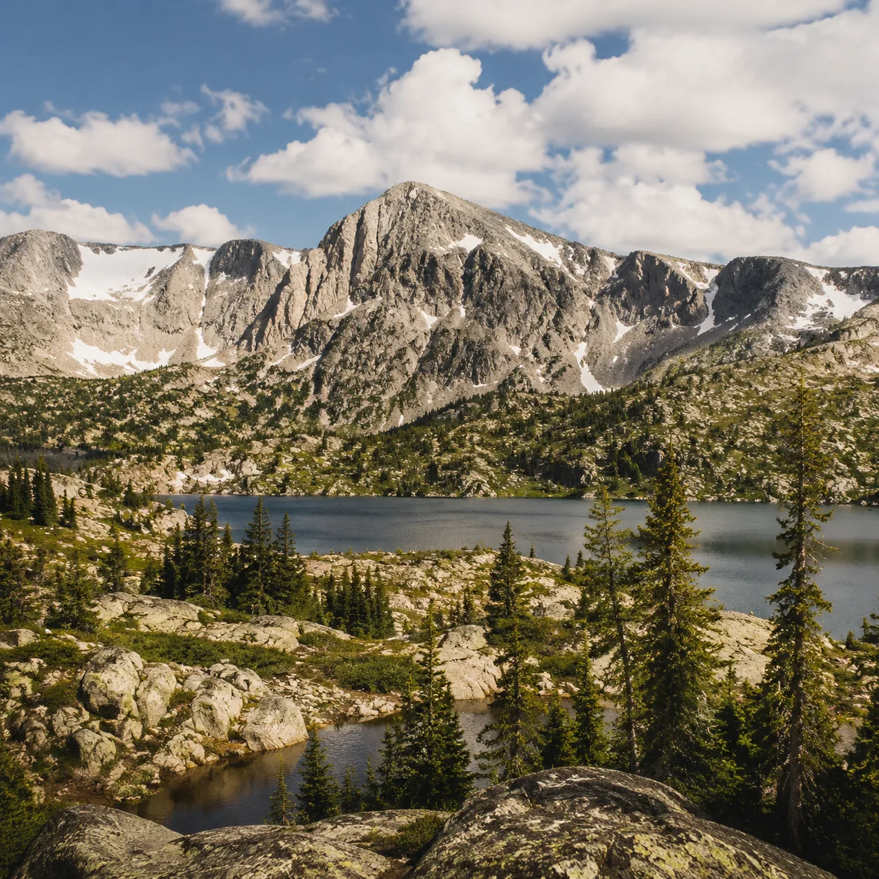 Realistic editorial photo of alpine lakes and granite peaks along Snowy Range Scenic Byway Wyoming, warm natural travel 