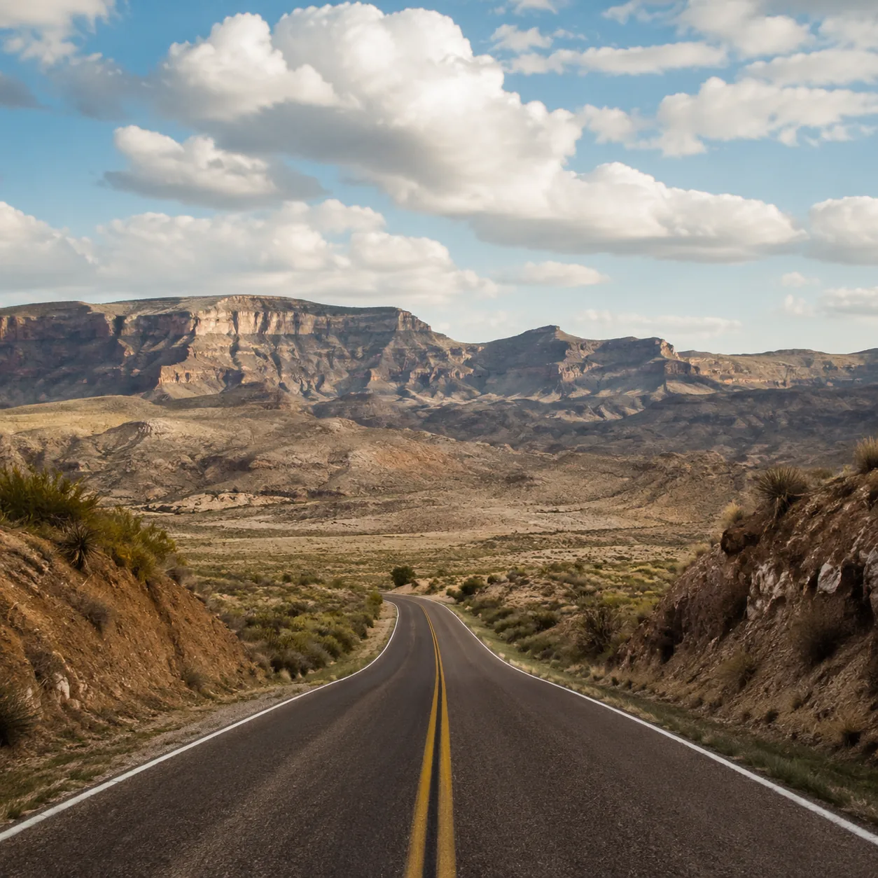 Realistic editorial photo of empty desert road through Big Bend Ranch State Park Texas with Rio Grande canyon landscape,